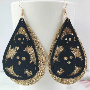 Detalle de pendientes fantasma de Halloween con lentejuelas doradas y fieltro negro