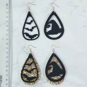 Halloween drop earrings featuring black bats, witch hats, and gold glitter finish on marble