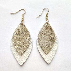 Detail of bohemian leather earrings with gold brown hair-on-hide and white textured layers