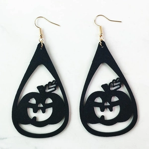 Detalle de pendientes de calabaza en cuero sintético negro con ganchos dorados