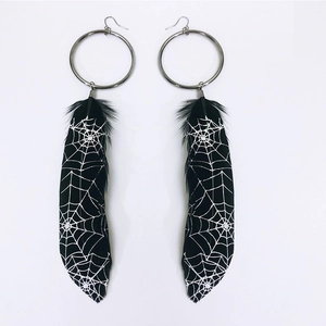 Gothic silver hoop earrings featuring black feathers with white spider web patterns