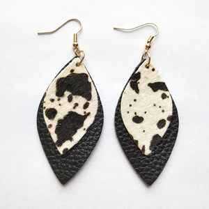 Detail of bohemian leaf earrings with cow print horsehair and black lychee leather