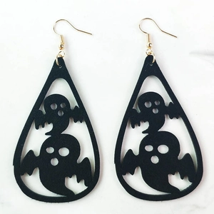 Detalle de pendientes de fantasma de Halloween con recortes negros y ganchos dorados
