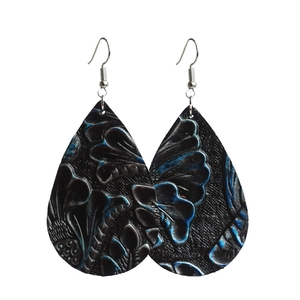 Détail de boucles d'oreilles bohèmes en cuir noir gaufré avec motifs floraux bleus élégants