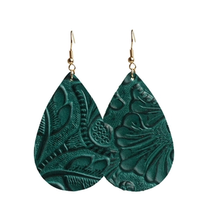 Détail macro de boucles d'oreilles goutte en cuir vert émeraude avec gaufrage vintage
