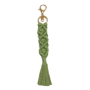 Close-up of grass green macrame keychain with boho fringe and gold lobster clasp
