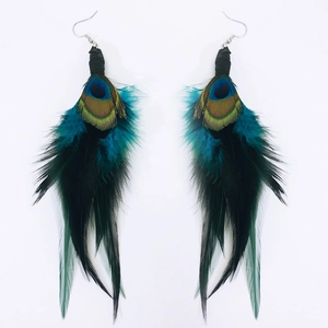 Close-up of bohemian long peacock feather earrings with metallic blue-green sheen