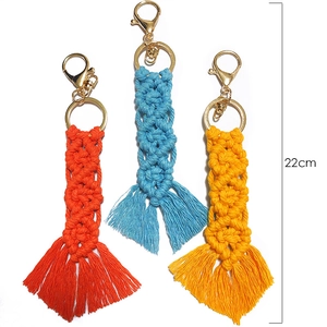 Detail showing three 22cm handmade macrame tassel keychains in orange, blue, and yellow