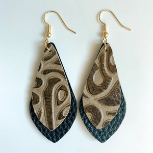 Détail de boucles d'oreilles en cuir embossé vintage avec motifs et crochets dorés