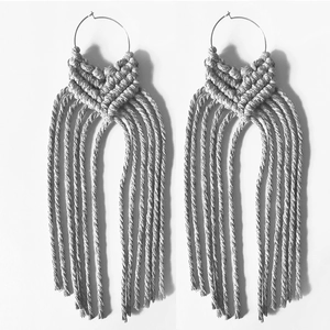 Detail of handcrafted macrame fringe earrings with geometric knots and metal hoops