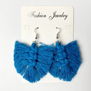 Macro view of handmade peacock blue woven tassel earrings with leaf-shaped cotton thread detail
