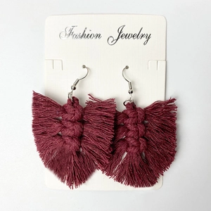 Detail of burgundy macrame tassel earrings with handmade bohemian fringe and metal hook