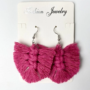 Close-up of handmade rose red woven tassel earrings on fashion jewelry card