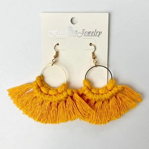 Detail of handmade bright yellow fringe earrings with golden hoop on display card