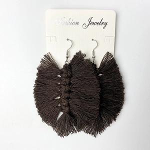 Detail of dark brown handmade woven tassel earrings with silver hooks on jewelry card
