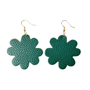 Détail de boucles d'oreilles fleur en cuir vert avec texture et crochets dorés