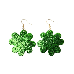 Détail macro de boucles d'oreilles fleur à paillettes vertes pour la Saint-Patrick