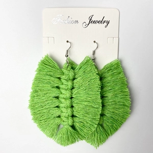 Handmade green woven leaf earrings with bohemian fringe style on display card