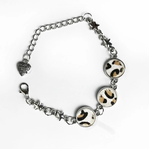 Detail of bohemian leopard print leather bracelet with star charms and heart tag