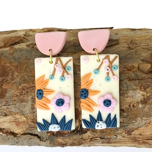 Handmade polymer clay rectangular earrings with 3D floral carvings on rustic wood block