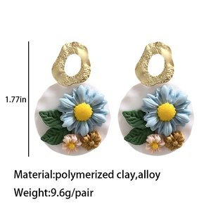 Handmade polymer clay daisy earrings with floral detail and golden metal rings