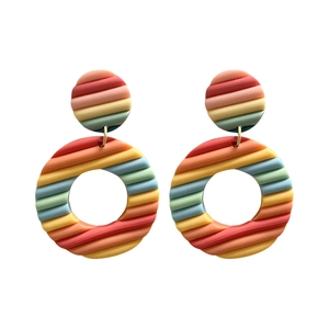 Handmade rainbow polymer clay earrings with vibrant multi-color stripes and circular design