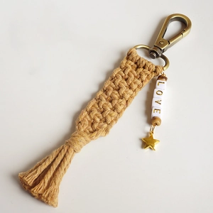 Handmade macrame keychain with LOVE beads, star pendant and fringe in mustard yellow