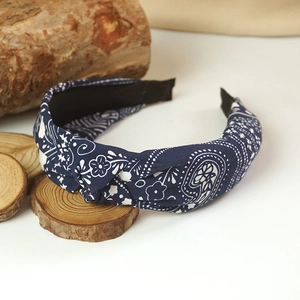 Close-up of dark blue paisley headband with knotted design and cotton texture details