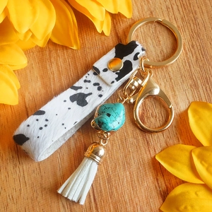 Portachiavi boho con stampa mucca, pietra turchese e nappa bianca su base di legno