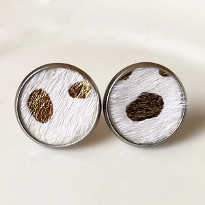 Vista macro de pendientes redondos de leopardo con piel sintética blanca y puntos dorados