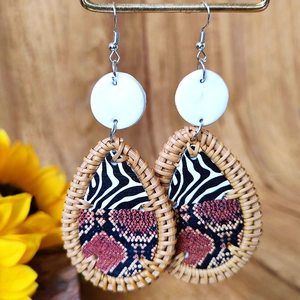 Macro detail of drop earrings featuring zebra print, snakeskin texture and rattan weaving