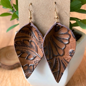 Pendientes de hoja de cuero marrón con relieve vintage y ganchos dorados en cartón