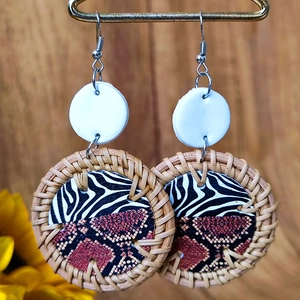 Macro view of handmade woven rattan earrings with zebra and snakeskin print details