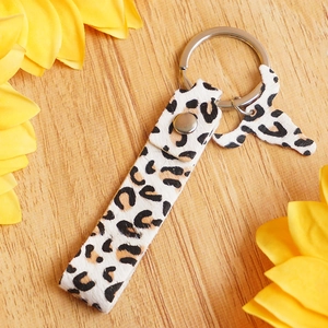 Detail view of leopard print leather keychain with bull head charm and silver metal ring