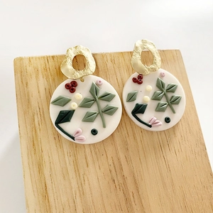 Handmade white clay floral hoop earrings with green leaves and pink buds and gold loops