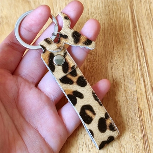 Handmade leopard print pony hair leather keychain with silver metal ring and rivet details