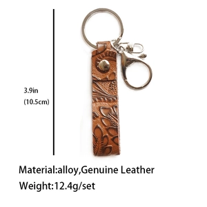 Detail of vintage brown genuine leather keychain with floral embossing and silver alloy ring