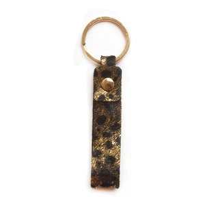 Detail of leopard print leather strap keychain with premium gold ring and metal rivet