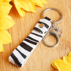 Detailed view of zebra print cowhide leather keychain with silver metal ring and lobster clasp