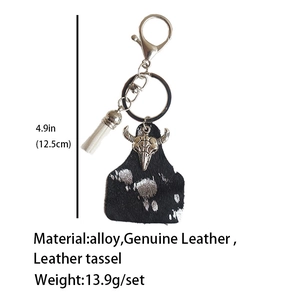 Detail of Western leather keychain with bull skull tag, white tassel, and alloy clip