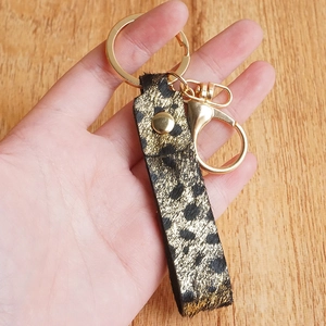 Handmade leopard print leather keychain with golden hardware and metallic finish studs