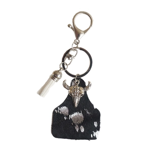 Western bull skull leather keychain with fringe tassels and metallic ring on white background