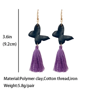 Detail of butterfly drop earrings with purple fringe tassels and black polymer clay charms