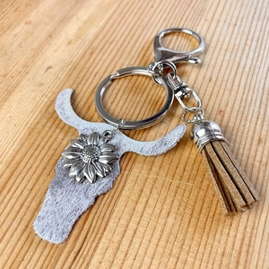 Western style cow skull keychain with gray fur, sunflower metal stud and brown fringe