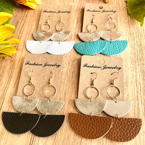 Set mit vier strukturierten Lederohrringen im Boho-Stil auf Holzoberfläche