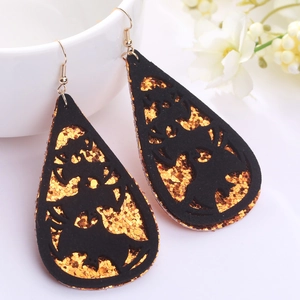 Vista macro de pendientes de Halloween con diseño de murciélago negro y purpurina naranja