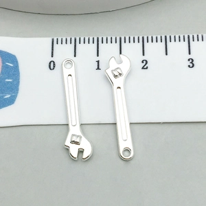 Dettaglio di mini ciondoli a forma di chiave inglese per gioielli fai-da-te con scala