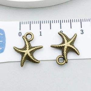 Detailansicht von Seestern-Anhängern in Bronze mit Lineal zur Größenanzeige