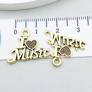 Détail du pendentif guitare en or antique I Love Music avec échelle de mesure