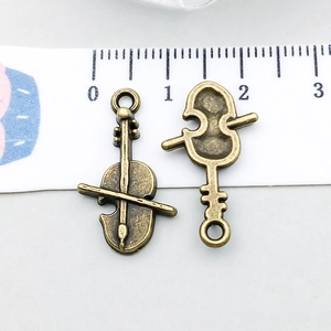 Dettaglio di ciondoli a forma di violino in bronzo antico per creazione di gioielli